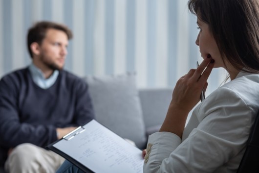 A guy is talking to the therapist about his trauma