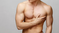 A young man with a well-built body holding his breast