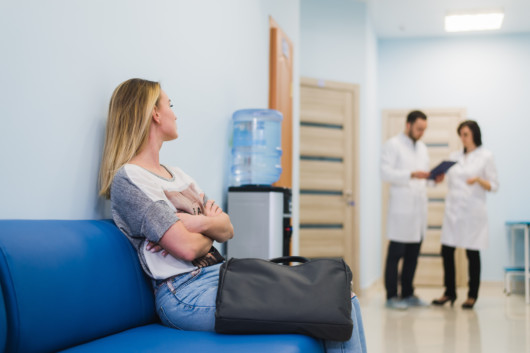 Woman patient waiting at hospital Doctors Waiting Room.