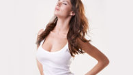 A girl with augmented breasts in white t-shirt on white background