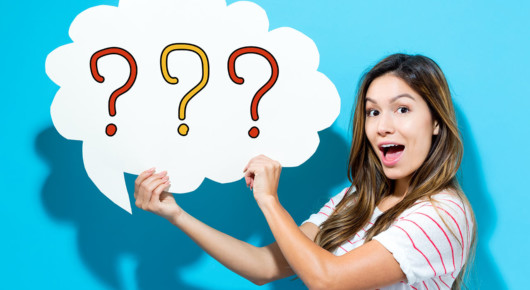 A lady with a surprised face on blue background is holding an image of a cloud with questions marks