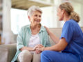 A doctor is talking to a senior lady in light green shirt