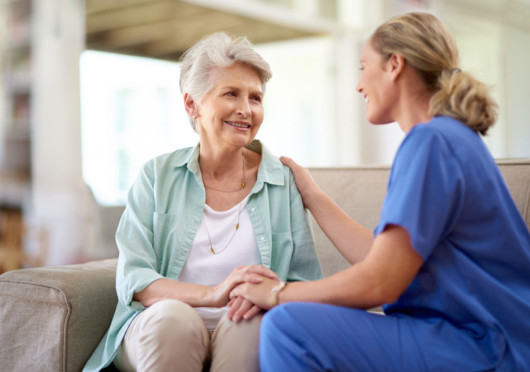 A doctor is talking to a senior lady in light green shirt